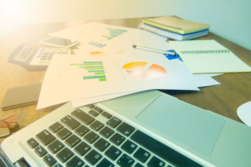 Fototapeta premium Business documents on office table with laptop, smart phone and graph financial. Business concept.