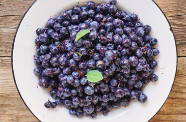 Fresh blueberries in a bowl on a wooden background
