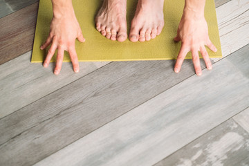 yoga training. sport and fitness. wellness lifestyle and regular gym workout. male feet and hands on a yoga mat preparing to exercise. copyspace concept.
