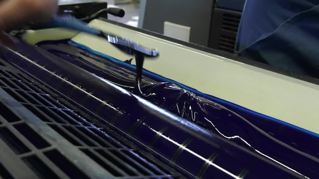 A large printing machine throws paper into a container.