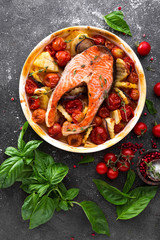 Grilled salmon fish steak with potato, onion and tomatoes. Baked salmon fish steak  with vegetables