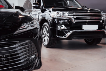 Naklejka premium New shining beautiful cars stand near desk reception in car shop