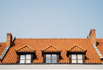 Old beautiful windows in roof covered with orange slate