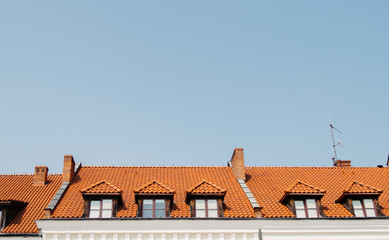 Old beautiful windows in roof covered with orange slate, copy space