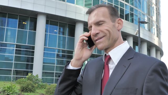 Walking Positive Businessman Talking on Phone