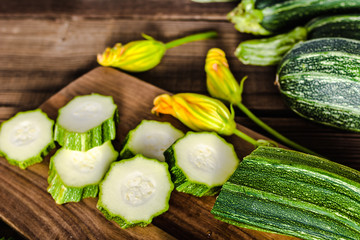 Fresh organic zucchini on table and sliced zucchinis, cooking healthy food with vegetarian...