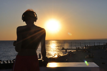 DJ plays music on the beach at sunset