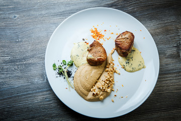 top view on two tasty pieces of grilled meat with puree and sauce