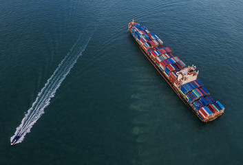 a cargo ship carrying multi-stack of containers in sea aerial view