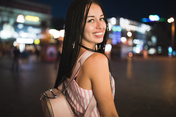 Sexy woman portrait with african pigtails in night city street