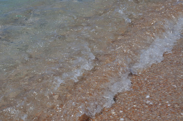 Tide waves on the beach with shells and sand
