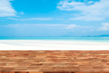 Perspective wooden table on top over blur sea in sunny day background. Beautiful sea and clouds in Thailand on summer, can be used mock up for montage products display or design layout.