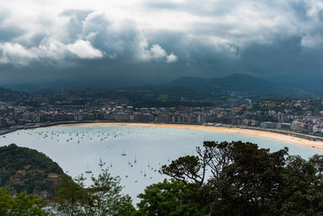 Naklejka premium Dark clouds over San Sebastian city, Basque contry, Spain.