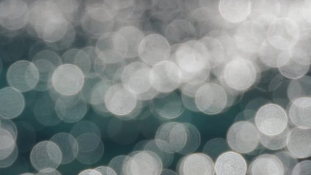 Blurry light spots from sunlight on the water surface.
