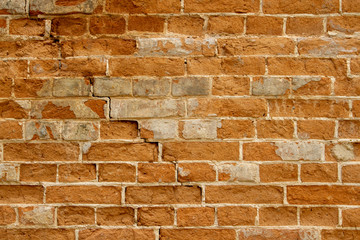 Collapsed red brick in the ancient wall during the restoration. Restoration of the crack of the brick wall of the 1600s. Restoration of plaster of an ancient brick wall by masters-restorers.