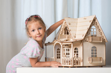 a girl playing with a dollhouse
