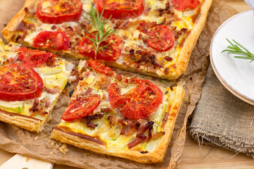 Puff pastry tart pizza style with tomatoes, courgette, and bacon