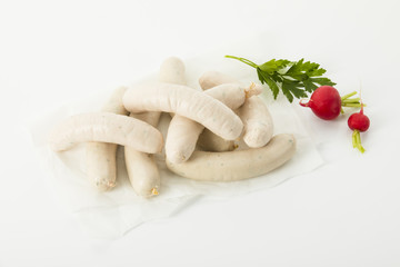 mehrere rohe Weißwürste mit Radieschen und Petersilie, Freisteller