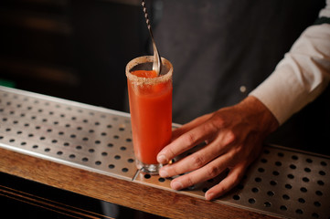 Fototapeta na wymiar Bartender stirring a bloody mary in the cocktail glass
