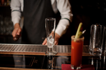 Bloody mary cocktail and empty glass with ice