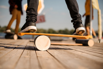 Man standing on the balance board on the wooden pier - obrazy, fototapety, plakaty