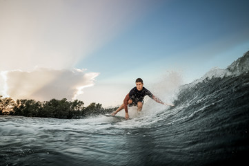 Man riding on the wakeboard on the bending knees