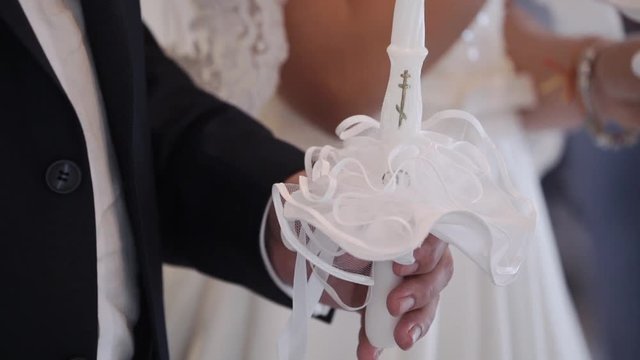 Bride and groom holding candles in church at christianity wedding ceremony