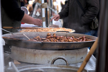 Street food being made in state fair. Traditional meat and sausages grilled in open air market for people. First barbecue party outdoors in spring