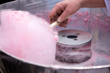 Cotton candy being made out of pink dyed sugar for joyful children. Concept of unhealthy eating, too much sugar. Diabetes.  
