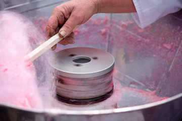 Cotton candy being made out of pink dyed sugar for joyful children. Concept of unhealthy eating, too much sugar. Diabetes.  
