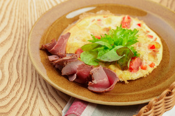 Delicious breakfast. Fried omlette with sliced ham close up