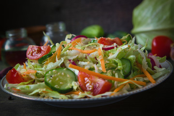 Fresh dietary salad of cucumbers, tomatoes, cabbages, radishes, carrots with sesame seeds, olive oil, garlic and herbs. Healthy meal. Detox and vegetarian concept.