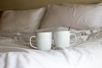 2 cups of coffee on bed