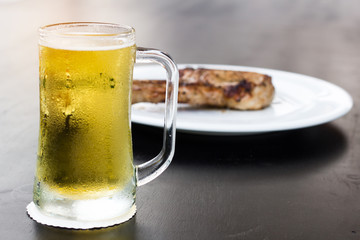 glass of beer with ice foam on a wooden background
