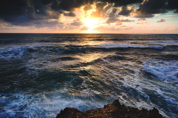 Beautiful bright colorful stunning sea sunset, rays of the sun in the clouds dramatic sunset over the ocean