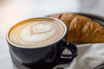 cup of coffee with cream on wooden background