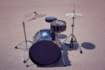 Fototapeta na wymiar close up view of black drum kit and drum sticks on street