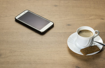 Fototapeta na wymiar Taza de café y teléfono móvil en una mesa