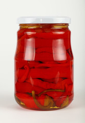 Jar of pickled red hot chili peppers over white