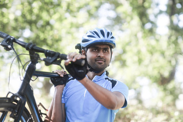 Junger Mann mit Helm und Trikot und Fahrrad