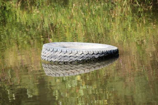 Tire carelessly thrown away in the nature /Carelessly discarded items pollute the environment and cause problems for all humanity