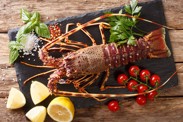 Preparation for cooking food spiny lobster or sea crayfish with fresh ingredients close-up on a...