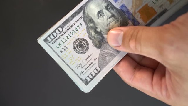 Guy considers money with his hands a close-up. Dollars in the arm closeup 4k.