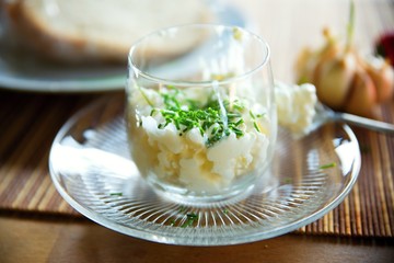 Cottage cheese with chive shoots in glass cup.