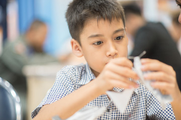 Little boy making an aircraft paper