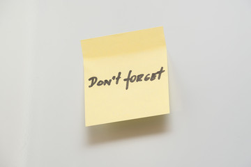 Yellow note reminder with handwritten memo