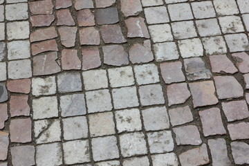 Cobbles close-up. An ancient road lined with a stone in Prague. Texture of smooth stones. Background old stone road in the city. Vintage pattern with natural material