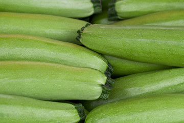 Light green fresh zucchini stacked in a heap shot from above