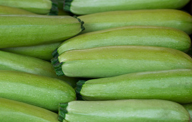 Light green fresh zucchini stacked in a heap shot from above