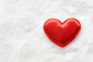 textile red heart on the background of white fur